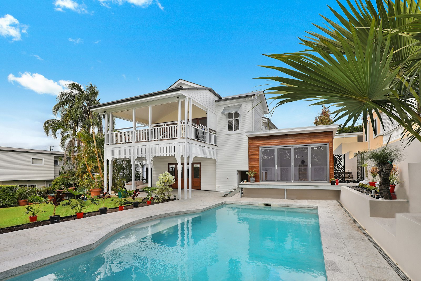 Bright backyard pool beside a modern white home