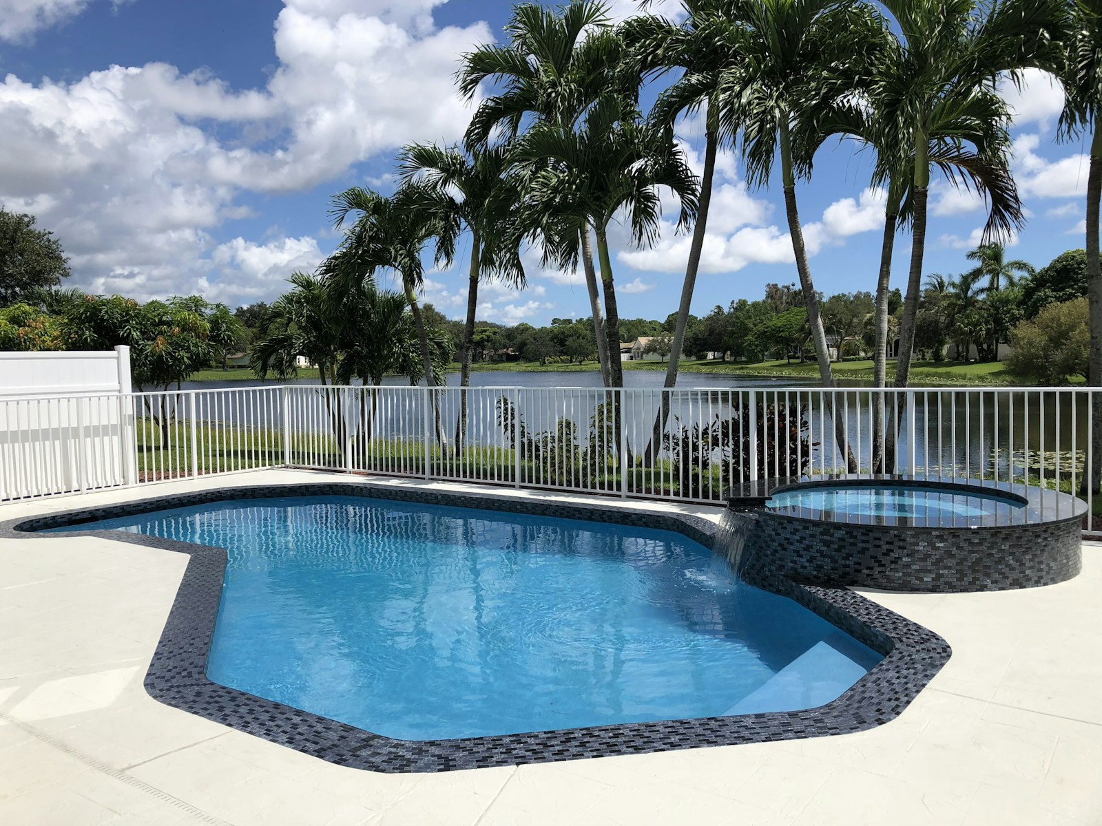 Freeform pool with attached spa and lake view